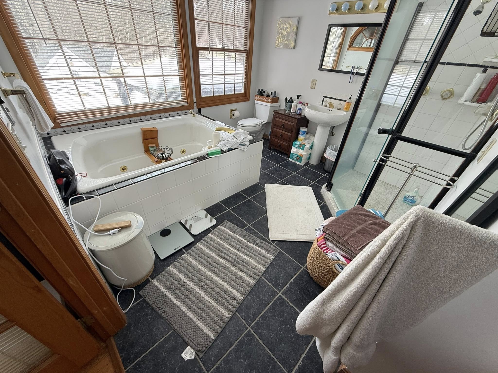Bathroom before renovation — dated dark tile and jacuzzi tub