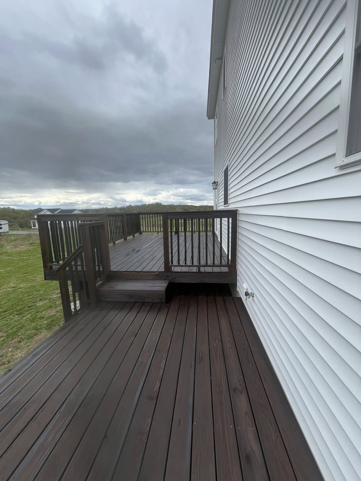 Completed dark composite deck along white house